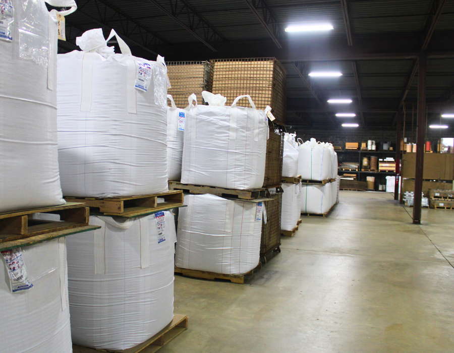 Pallets of large bags of sand inside a warehouse